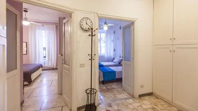 a room with a clock on the wall and a bedroom at Rental in Rome Otranto Relax in Rome