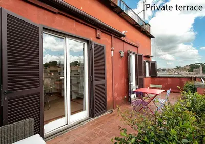 a balcony with sliding glass doors and a table on a patio at Paradiso Penthouse - FromHometoRome in Rome