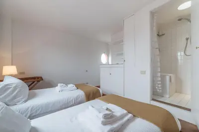 a room with two beds and a bathroom with a shower at Paradiso Penthouse - FromHometoRome in Rome