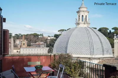 a balcony with a table and a domed building at Paradiso Penthouse - FromHometoRome in Rome