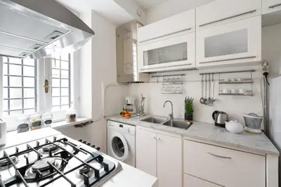 a white kitchen with a stove and a sink at Your Home at Campo de' Fiori in Rome