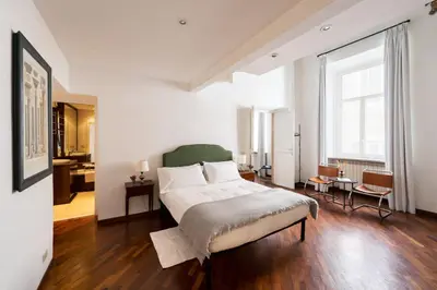 a bedroom with a bed and a large window at Your Home at Campo de' Fiori in Rome