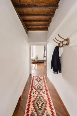 a hallway with a rug on the floor and a wooden ceiling at Your Home at Campo de' Fiori in Rome