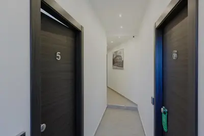 a hallway with two wooden doors and a stairway at Domus Arena in Rome