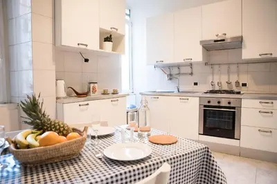 a kitchen with a table with a bowl of fruit on it at Porta Latina Apartment in Rome