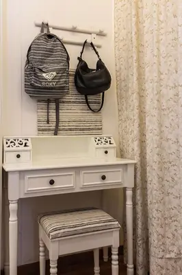 a white dressing table with a bag and a stool at Monticello apartment via Cavour in Rome