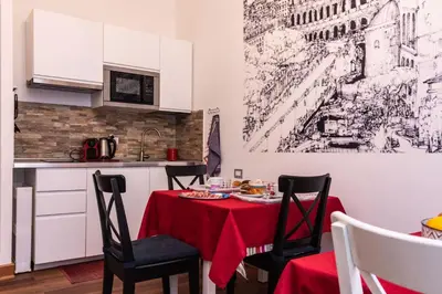 a small kitchen with a table with a red table cloth at Monticello apartment via Cavour in Rome