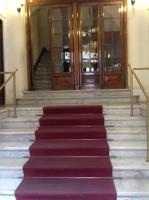 a red carpeted staircase leading to a revolving door at A casa di Fiamma in Rome