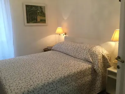a bedroom with a bed and two lamps and a window at A casa di Fiamma in Rome