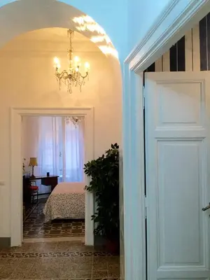a bedroom with a bed and a chandelier at A casa di Fiamma in Rome