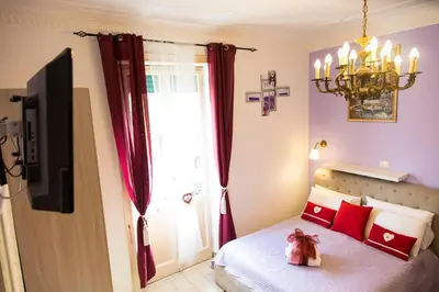a bedroom with a bed with red pillows and a window at Sweet Sleep Vatican in Rome