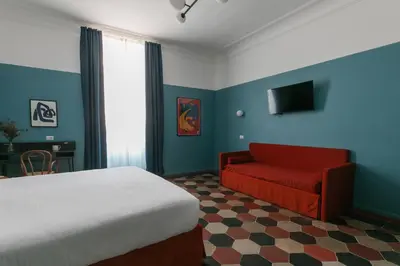 a bedroom with a bed and a red chair at Passepartout in Rome
