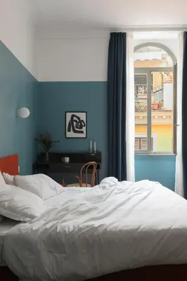 a bedroom with a bed and a desk and a window at Passepartout in Rome