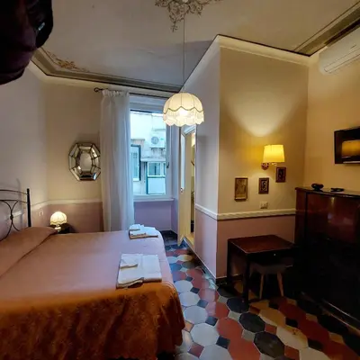 a bedroom with a bed and a table and a window at Residenza Maritti Decò Style- Guesthouse in Rome