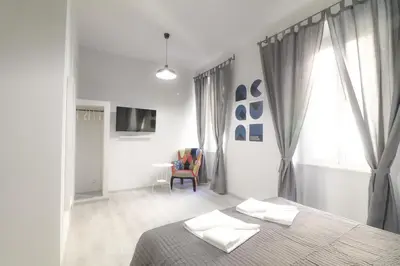 a white bedroom with a bed and a window at CinqueSogni Guest House in Rome