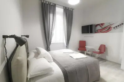 a bedroom with a bed with two chairs and a window at CinqueSogni Guest House in Rome