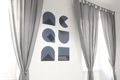 a room with gray curtains and a wall with posters at CinqueSogni Guest House in Rome