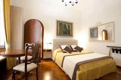 a bedroom with a bed and a table and a desk at Guesthouse Borromeo Roma in Rome