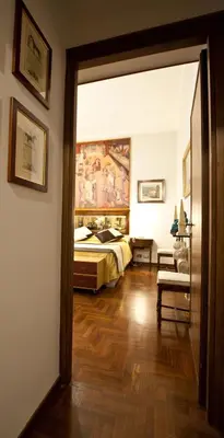 a bedroom with a bed and a painting on the wall at Guesthouse Borromeo Roma in Rome