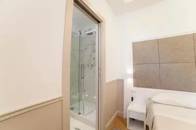 a bedroom with a glass shower and a bed at Margherita Suites in Rome