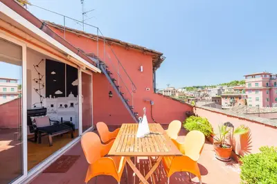 a patio with a wooden table and chairs on a balcony at Il Nascondiglio del Prete in Rome