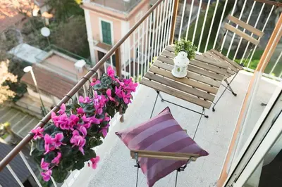 an umbrella and a bench on a balcony with flowers at Il Pesco Al Vaticano in Rome