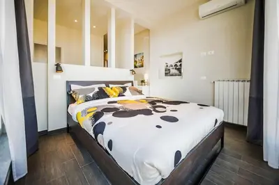 a bedroom with a large bed with a black and white comforter at Il Pesco Al Vaticano in Rome