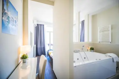 a white bathroom with a tub and a table at Il Pesco Al Vaticano in Rome