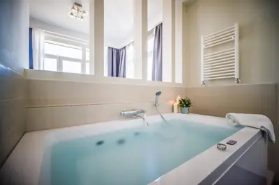 a bathroom with a tub and a large mirror at Il Pesco Al Vaticano in Rome