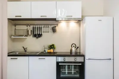 a kitchen with white cabinets and a stove top oven at Il Pesco Al Vaticano in Rome