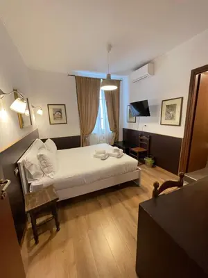 a hotel room with a bed and a television at Gold House in Rome