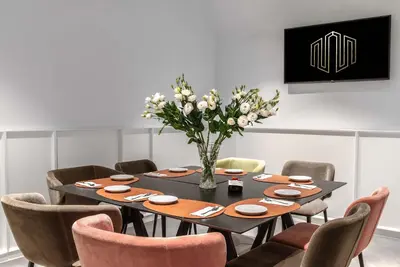 a dining room with a table with chairs and a vase of flowers at Navona Street Hotel in Rome