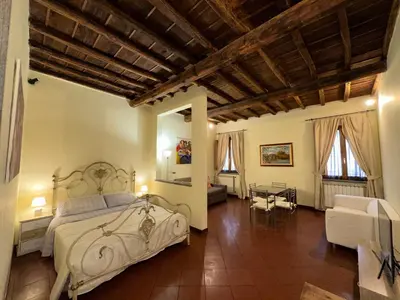 a bedroom with a bed and a couch and a table at Navona Apartment Livia in Rome