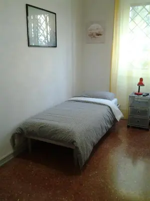 a bedroom with a bed and a dresser and a window at Long Bridge House in Rome