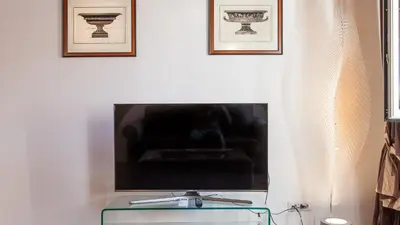 a tv sitting on top of a table in a living room at Rental in Rome - Scala Suite in Rome