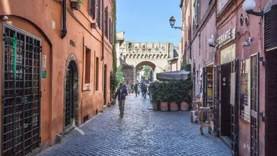 a person walking down a cobblestone street in a city at Rental in Rome - Scala Suite in Rome