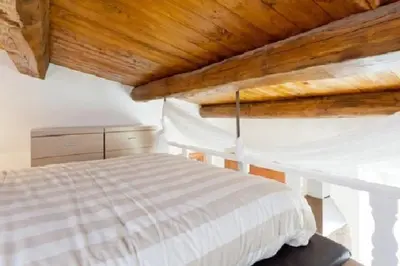 a bedroom with a white bed with a wooden ceiling at Brancaleone86 - The Loft in Rome