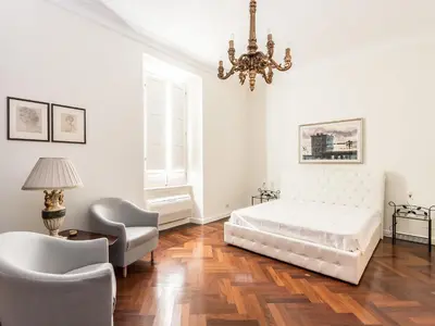 a bedroom with a bed and a chair and a chandelier at Apartment Silla by Interhome in Rome