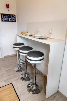 a bar with two stools and a counter with wine glasses at Sapienza Apartment by RHR in Rome