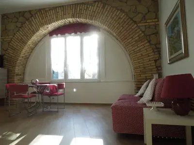 a living room with a red couch and a window at A Casa Di Lucia in Rome