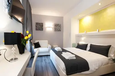 a bedroom with a bed and a couch and a chair at Brunelleschi Holidays Hostel in Rome