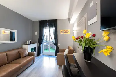 a living room with a couch and a table with yellow flowers at Brunelleschi Holidays Hostel in Rome