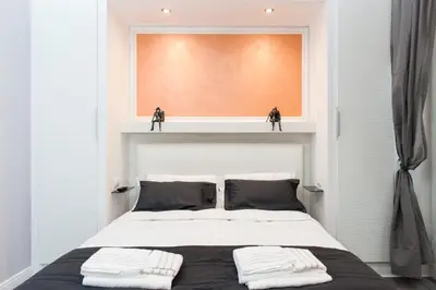a bedroom with a bed with two black and white pillows at Brunelleschi Holidays Hostel in Rome