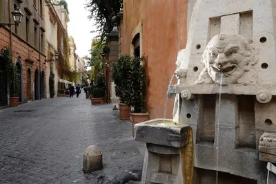a fountain with a lion head on the side of a street at Margutta Mews in Rome