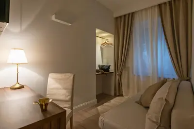 a bedroom with a bed and a desk with a lamp at Aruna Suites in Rome