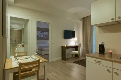a kitchen and living room with a table and a bed at Aruna Suites in Rome
