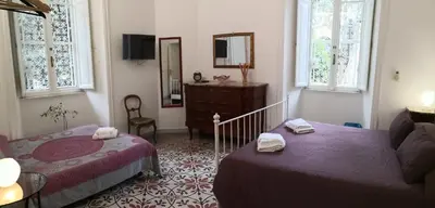 a bedroom with two beds and a couch and a mirror at B&B Domus Aurea in Rome