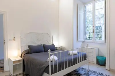 a white bedroom with a bed and a window at B&B Domus Aurea in Rome