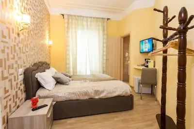a bedroom with a bed and a desk and a television at BQ House Castello Luxury Rooms in Rome