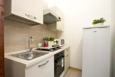 a small kitchen with a sink and a refrigerator at BQ House Castello Luxury Rooms in Rome